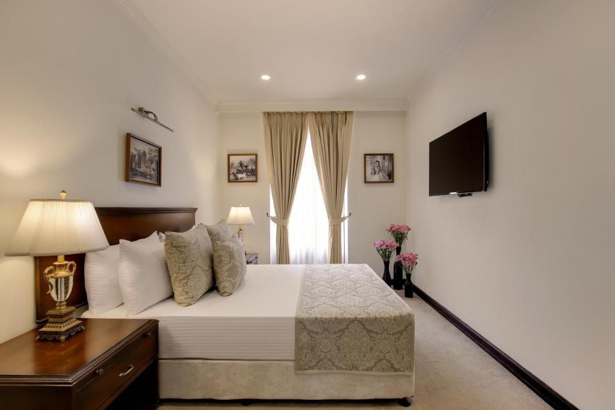 a bedroom with a large bed and a television at Ambassador, New Delhi - IHCL SeleQtions in New Delhi a bedroom with a large bed and a television at Ambassador, New Delhi - IHCL SeleQtions in New Delhi