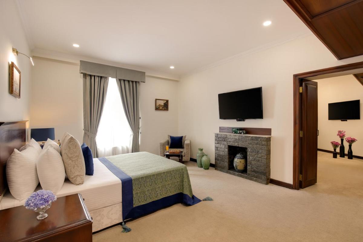 a hotel room with a bed and a fireplace at Ambassador, New Delhi - IHCL SeleQtions in New Delhi a hotel room with a bed and a fireplace at Ambassador, New Delhi - IHCL SeleQtions in New Delhi