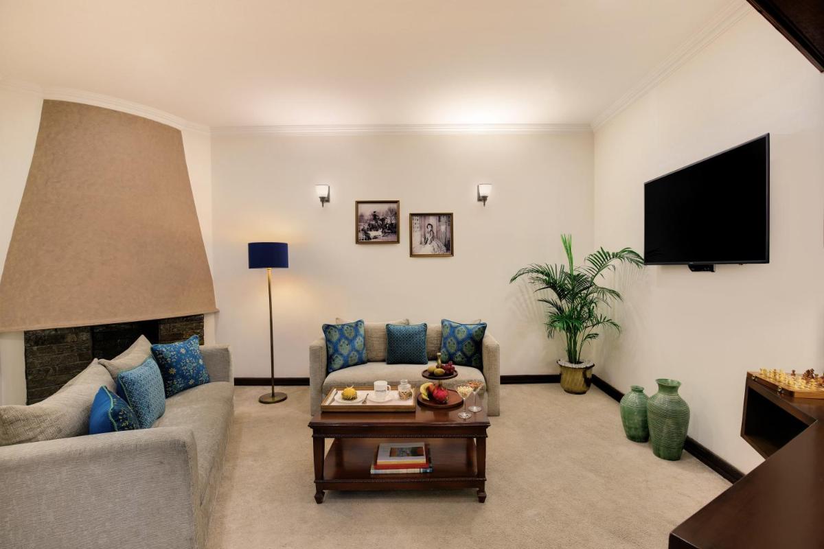 a living room with a couch and a tv at Ambassador, New Delhi - IHCL SeleQtions in New Delhi a living room with a couch and a tv at Ambassador, New Delhi - IHCL SeleQtions in New Delhi