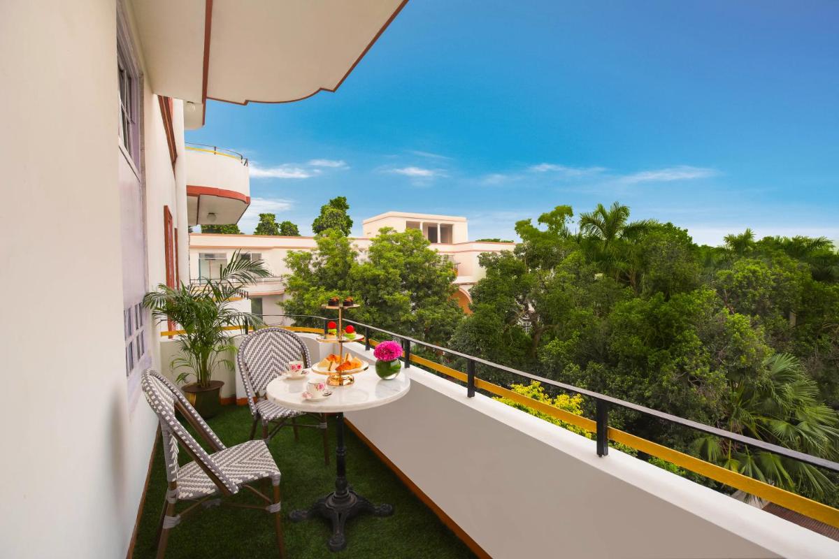 a balcony of a building with a table and chairs at Ambassador, New Delhi - IHCL SeleQtions in New Delhi a balcony of a building with a table and chairs at Ambassador, New Delhi - IHCL SeleQtions in New Delhi