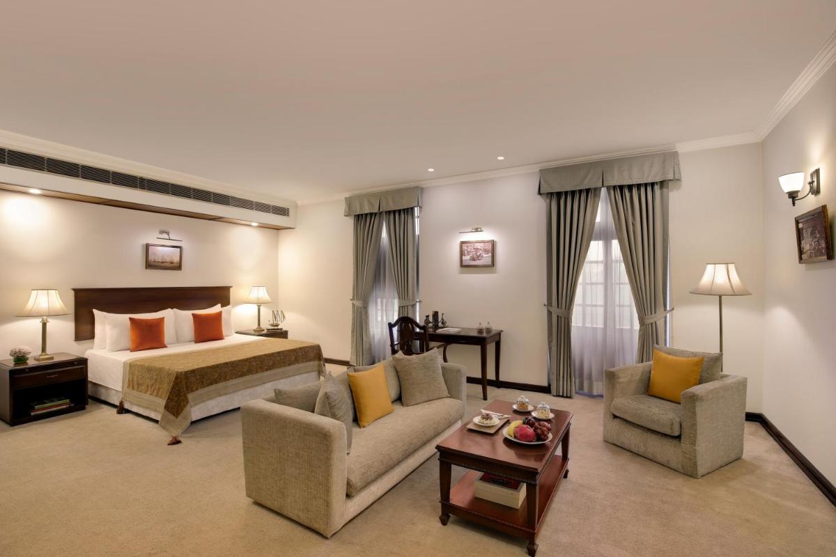 a hotel room with a bed and two chairs at Ambassador, New Delhi - IHCL SeleQtions in New Delhi a hotel room with a bed and two chairs at Ambassador, New Delhi - IHCL SeleQtions in New Delhi