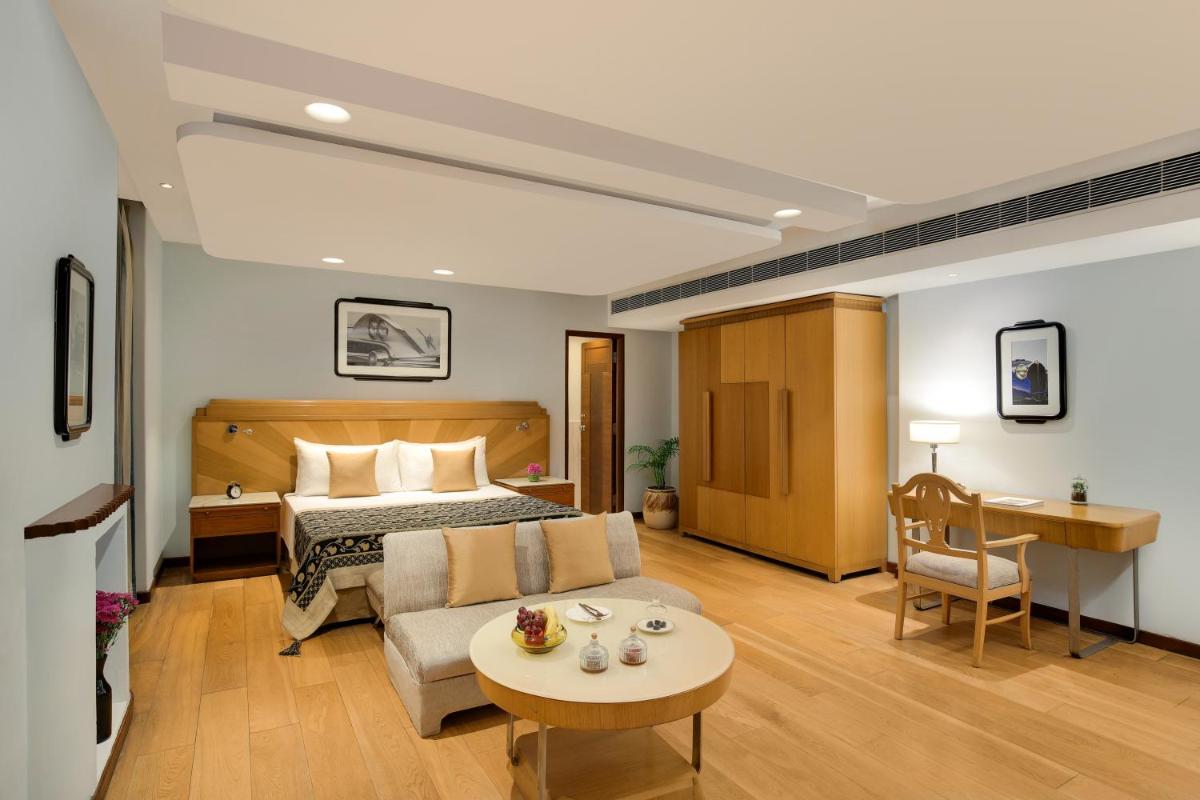 a room with a bed and a couch and a table at Ambassador, New Delhi - IHCL SeleQtions in New Delhi a room with a bed and a couch and a table at Ambassador, New Delhi - IHCL SeleQtions in New Delhi