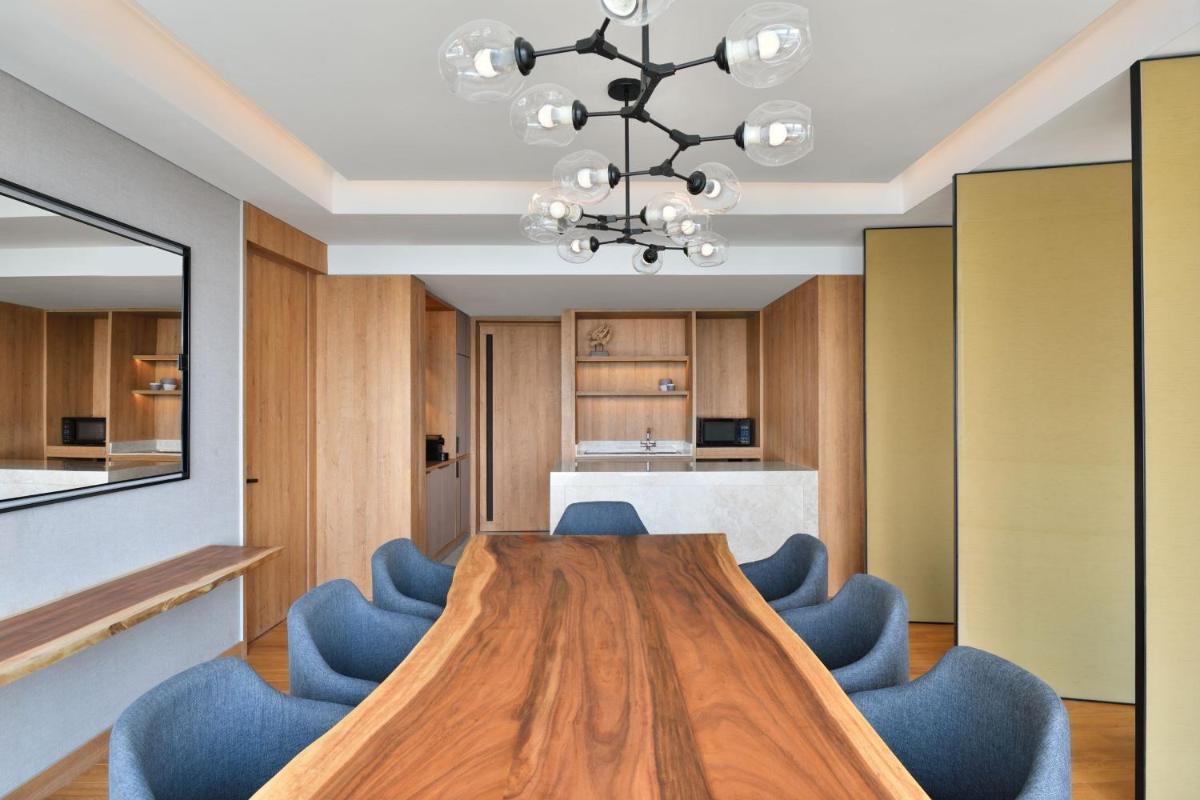 a conference room with a wooden table and blue chairs at The Westin Mumbai Powai Lake in Mumbai
