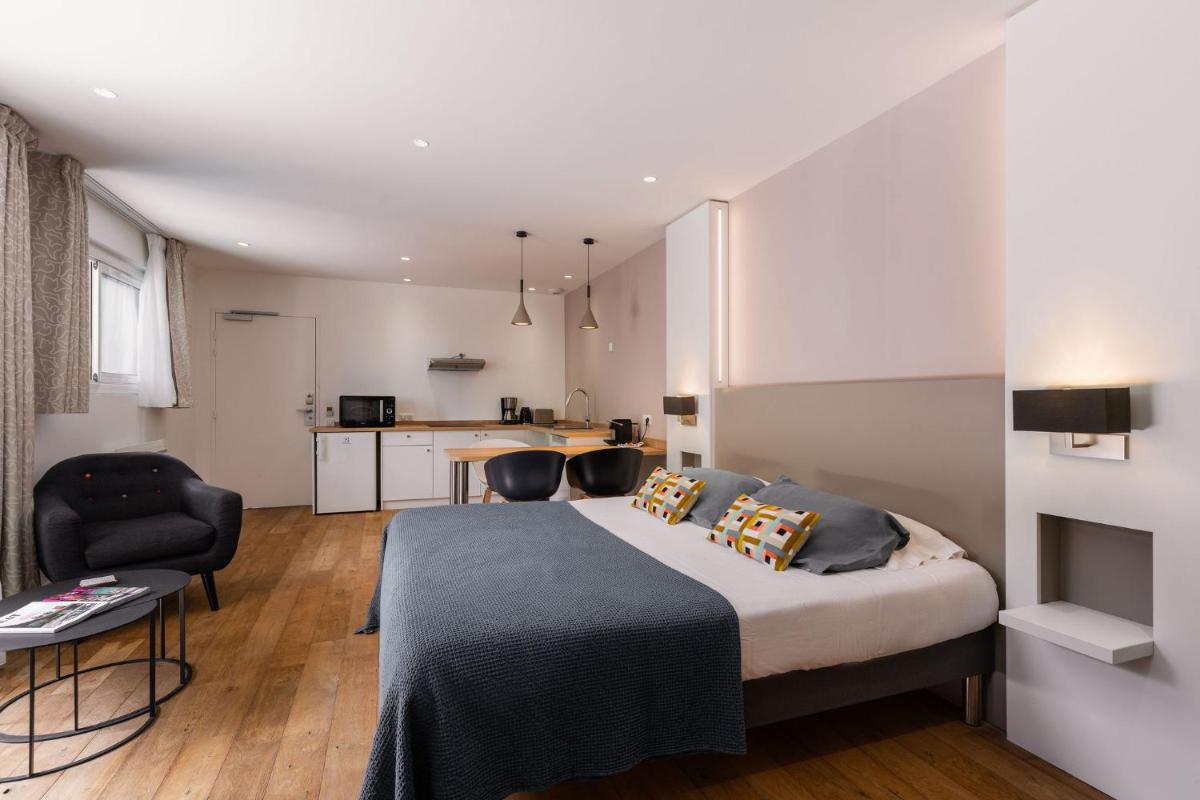 une chambre avec un lit, une table et des chaises dans l'établissement Le Cornouaille Hotel & Spa, à Bénodet 41 autres photos