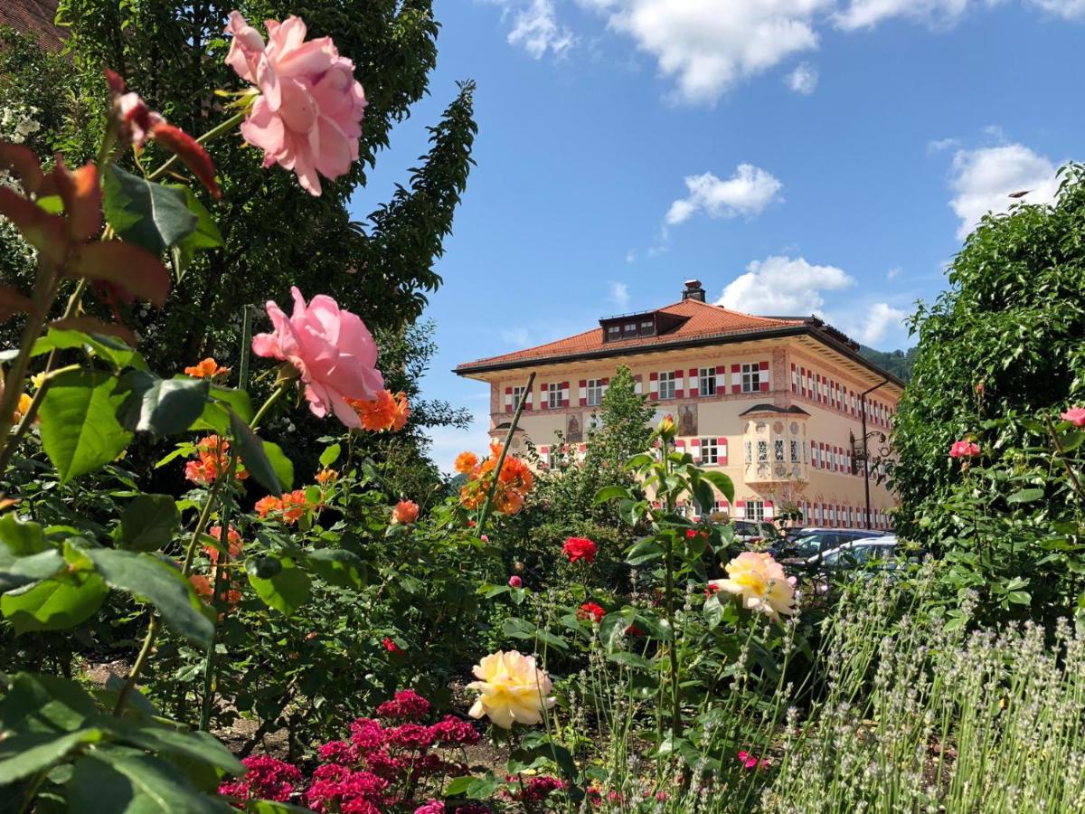 ein Garten mit Blumen vor einem Gebäude in der Unterkunft Boutique Hotel Residenz Winkler in Aschau im Chiemgau