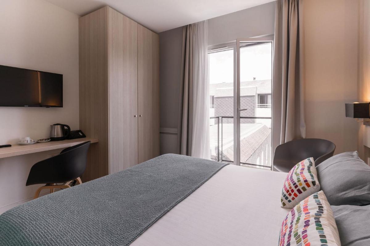 Un ou plusieurs lits dans un hébergement de l'établissement Le Cornouaille Hotel & Spa