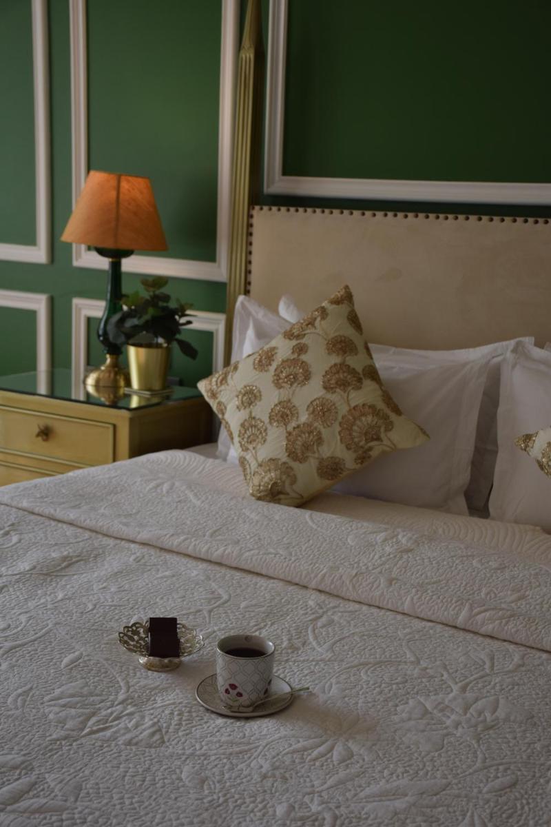 a bed with a cup of coffee on top of it at Dileep Kothi - A Royal Boutique Luxury Suites in Jaipur in Jaipur