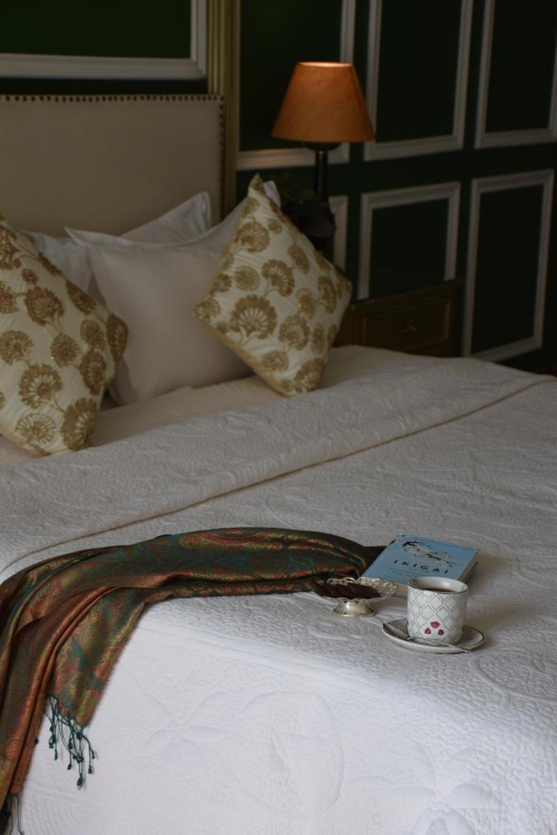 a bed with a cup of coffee on top of it at Dileep Kothi - A Royal Boutique Luxury Suites in Jaipur in Jaipur