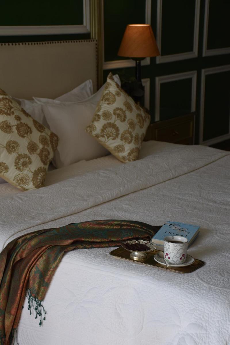 a tray with a cup and a plate on a bed at Dileep Kothi - A Royal Boutique Luxury Suites in Jaipur in Jaipur
