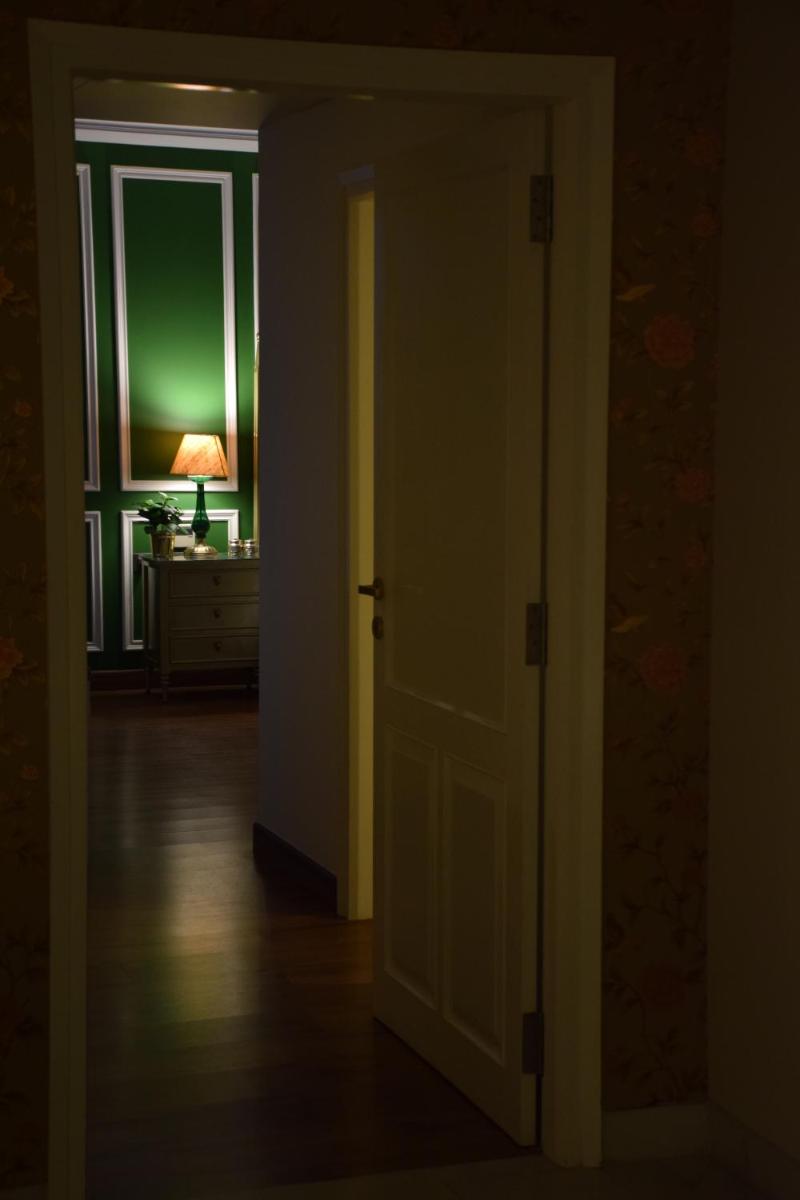an open door in a room with a lamp on a dresser at Dileep Kothi - A Royal Boutique Luxury Suites in Jaipur in Jaipur