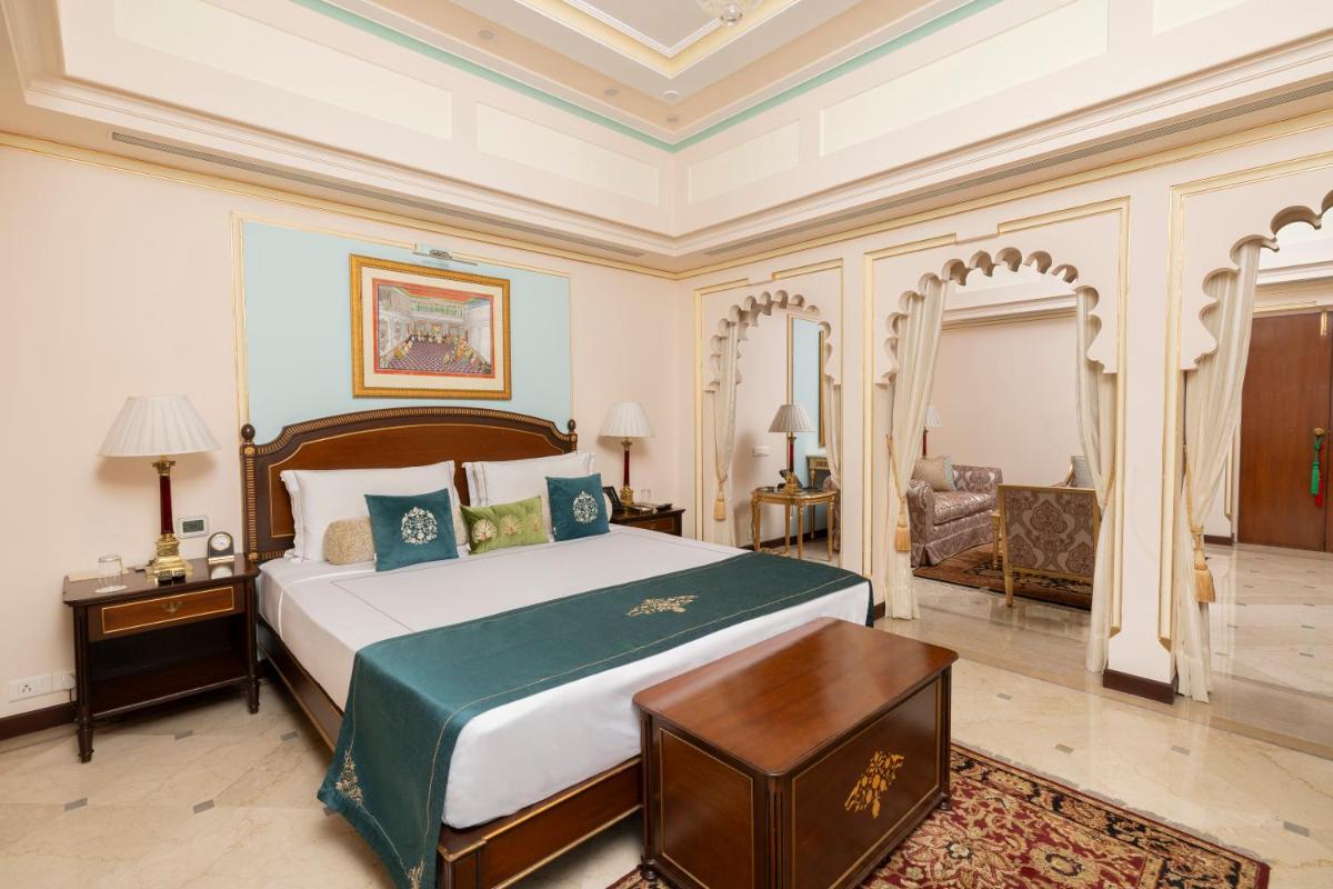 a bedroom with a bed and a table in a room at Taj Fateh Prakash Palace Udaipur in Udaipur