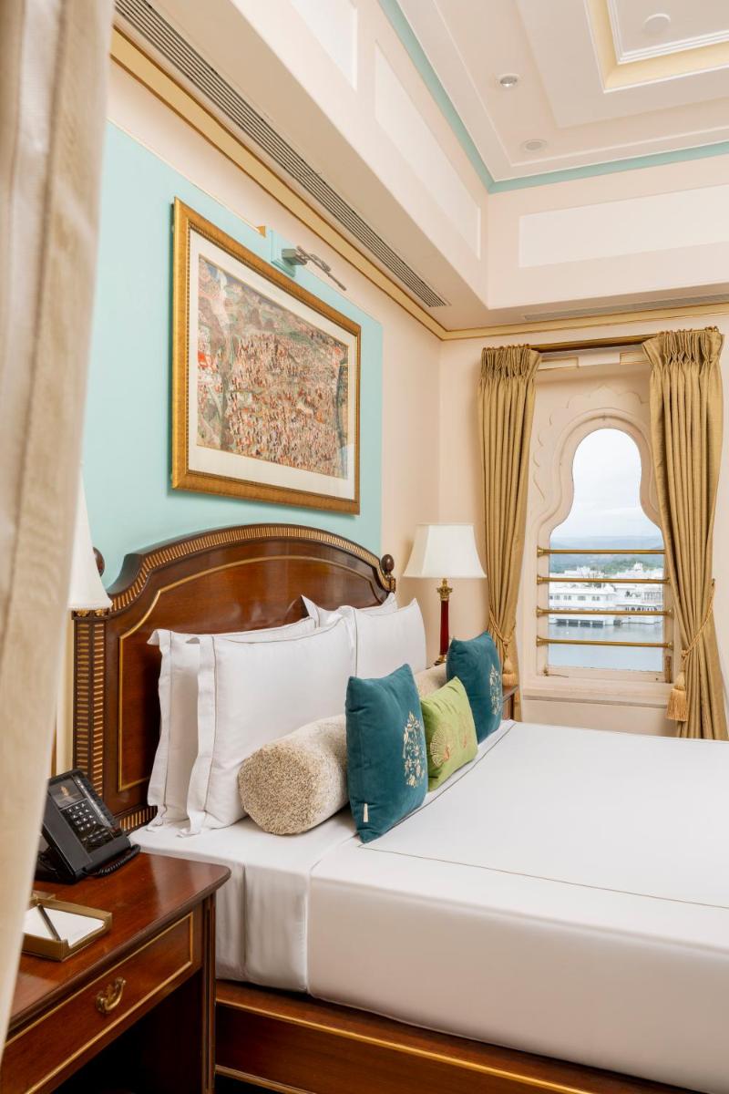 a bed in a room with a desk and a bed sidx sidx sidx at Taj Fateh Prakash Palace Udaipur in Udaipur