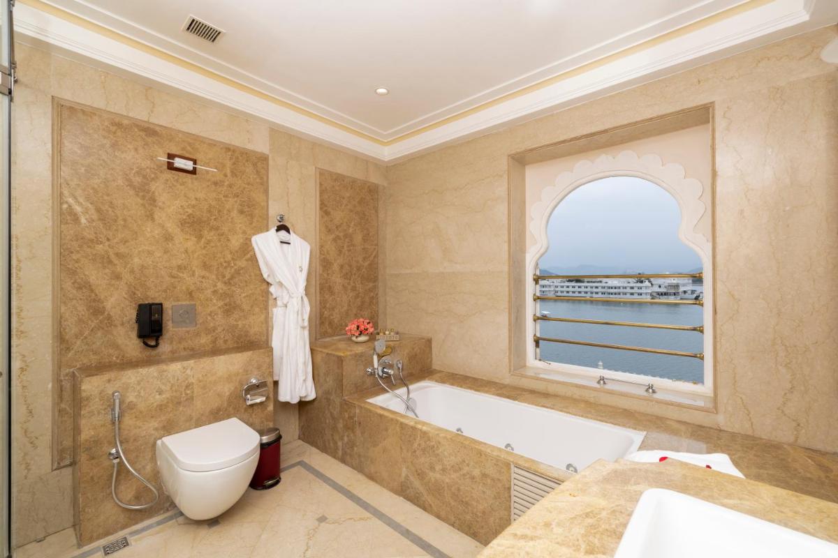 a bathroom with a tub and a toilet and a sink at Taj Fateh Prakash Palace Udaipur in Udaipur