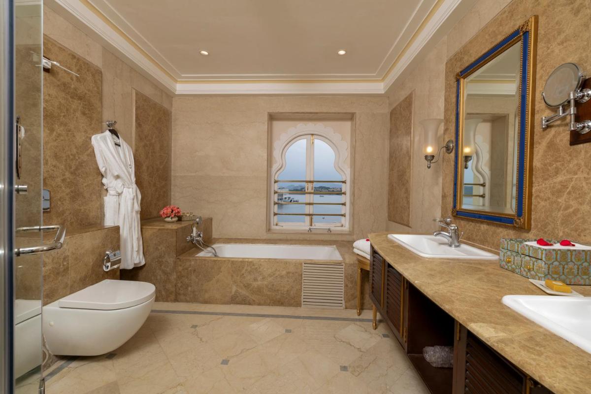 a bathroom with a tub and a toilet and a sink at Taj Fateh Prakash Palace Udaipur in Udaipur