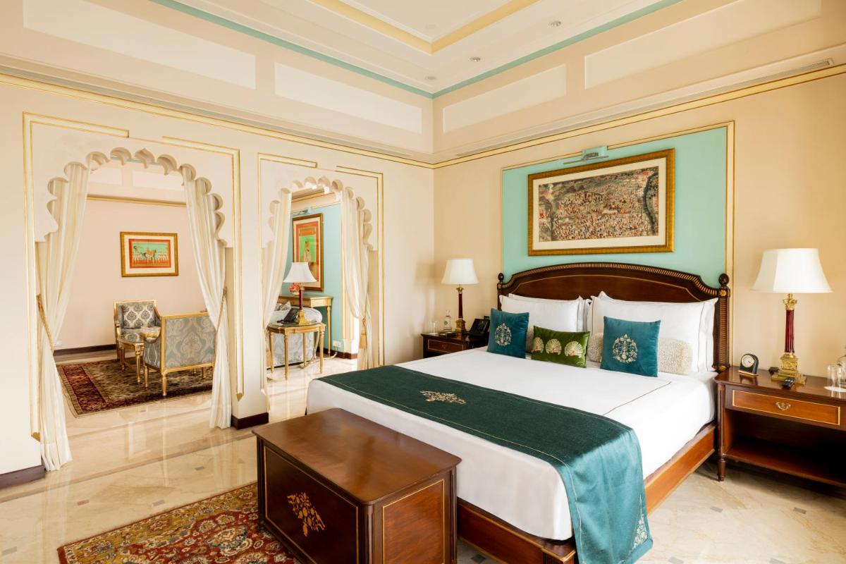 a bedroom with a large bed with a green blanket at Taj Fateh Prakash Palace Udaipur in Udaipur