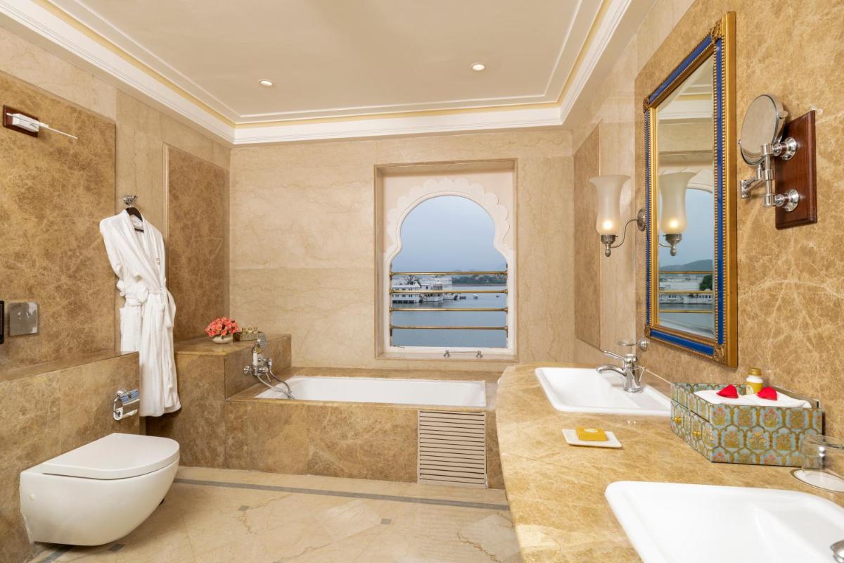 a bathroom with a tub and a toilet and a sink at Taj Fateh Prakash Palace Udaipur in Udaipur
