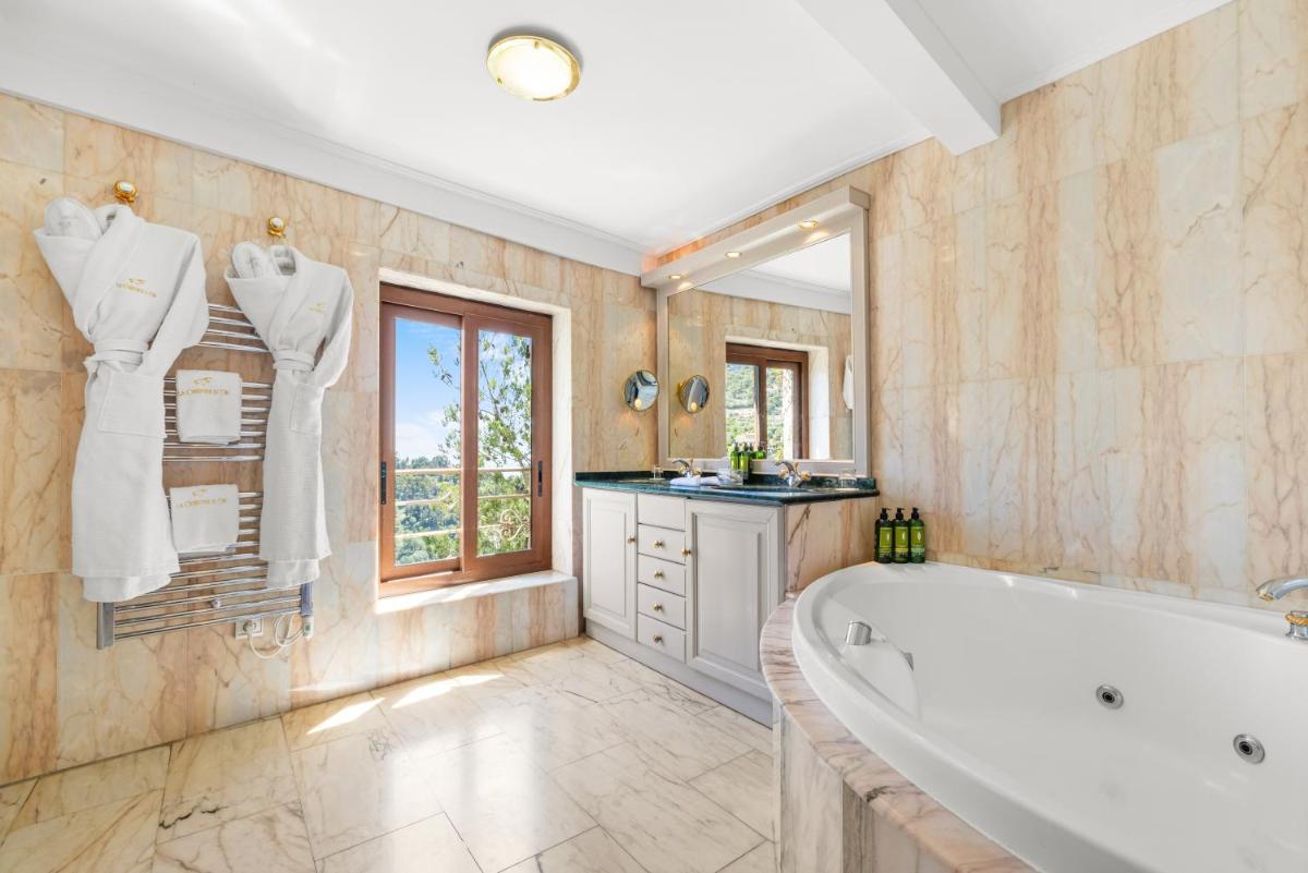 La grande salle de bains est pourvue d'une baignoire et d'une fenêtre. dans l'établissement La Chèvre d'Or, à Èze