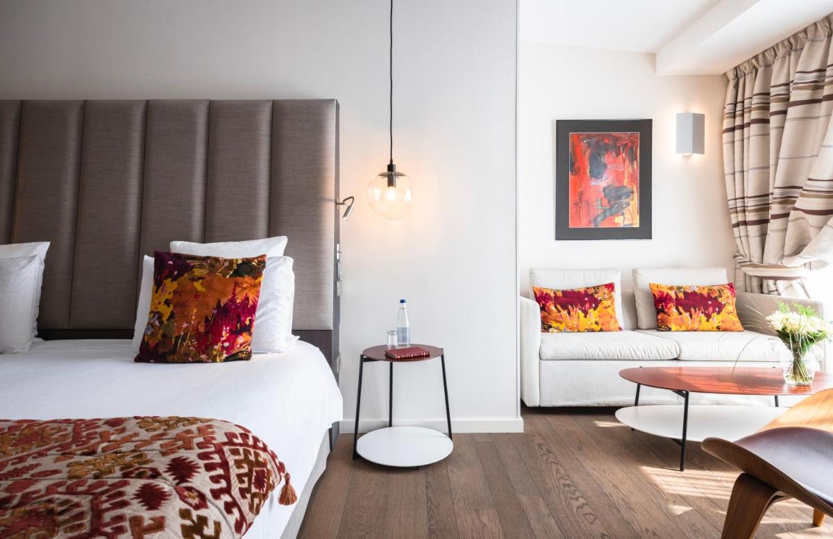 une chambre d'hôtel avec un lit et un canapé dans l'établissement Hotel & Spa REGENT PETITE FRANCE, à Strasbourg