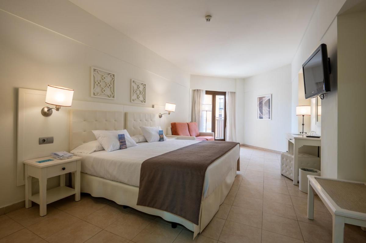 una habitación de hotel con una cama y un televisor en Vila Gale Isla Canela, en Isla Canela
