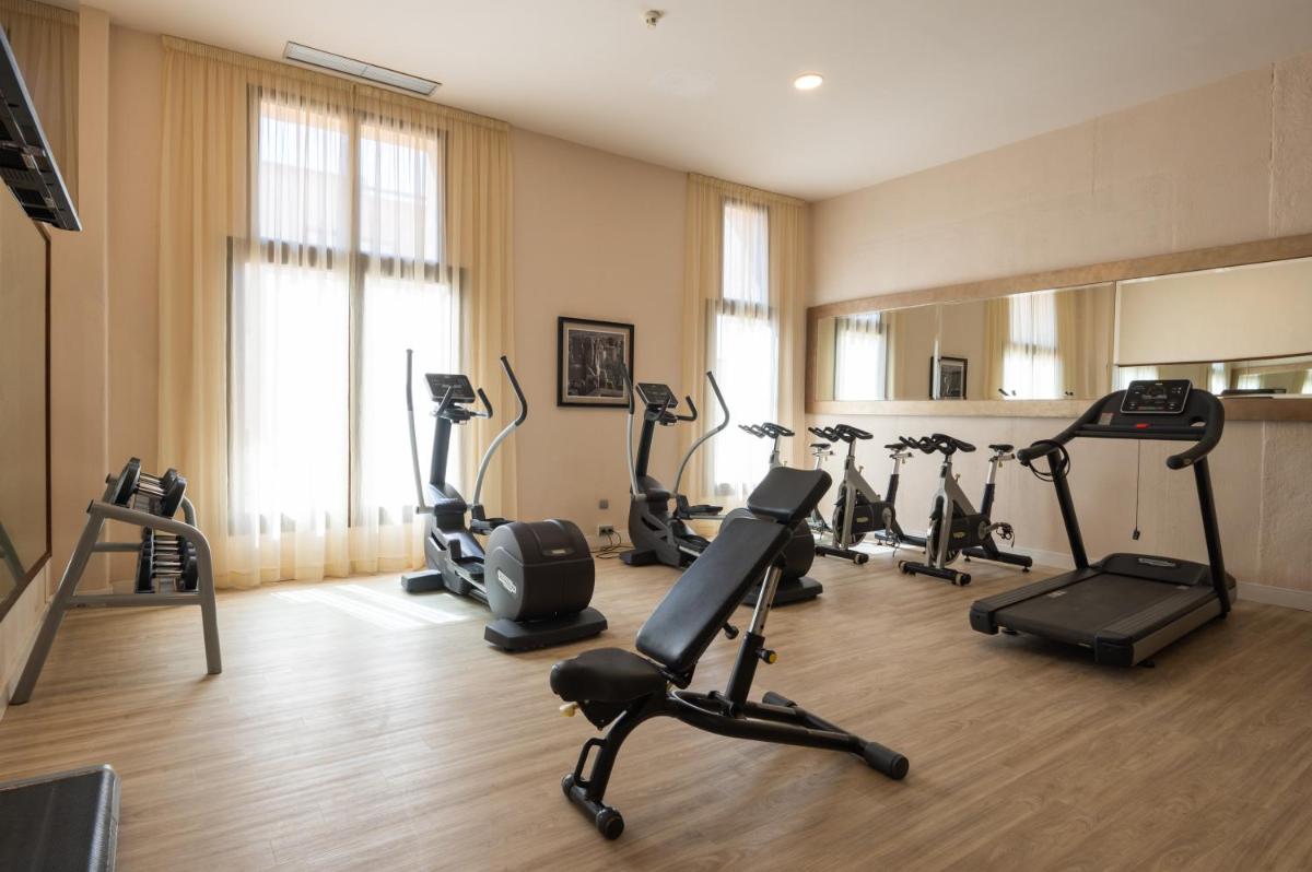 Un gimnasio con cintas de correr y bicicletas estáticas en una habitación. en Vila Gale Isla Canela, en Isla Canela