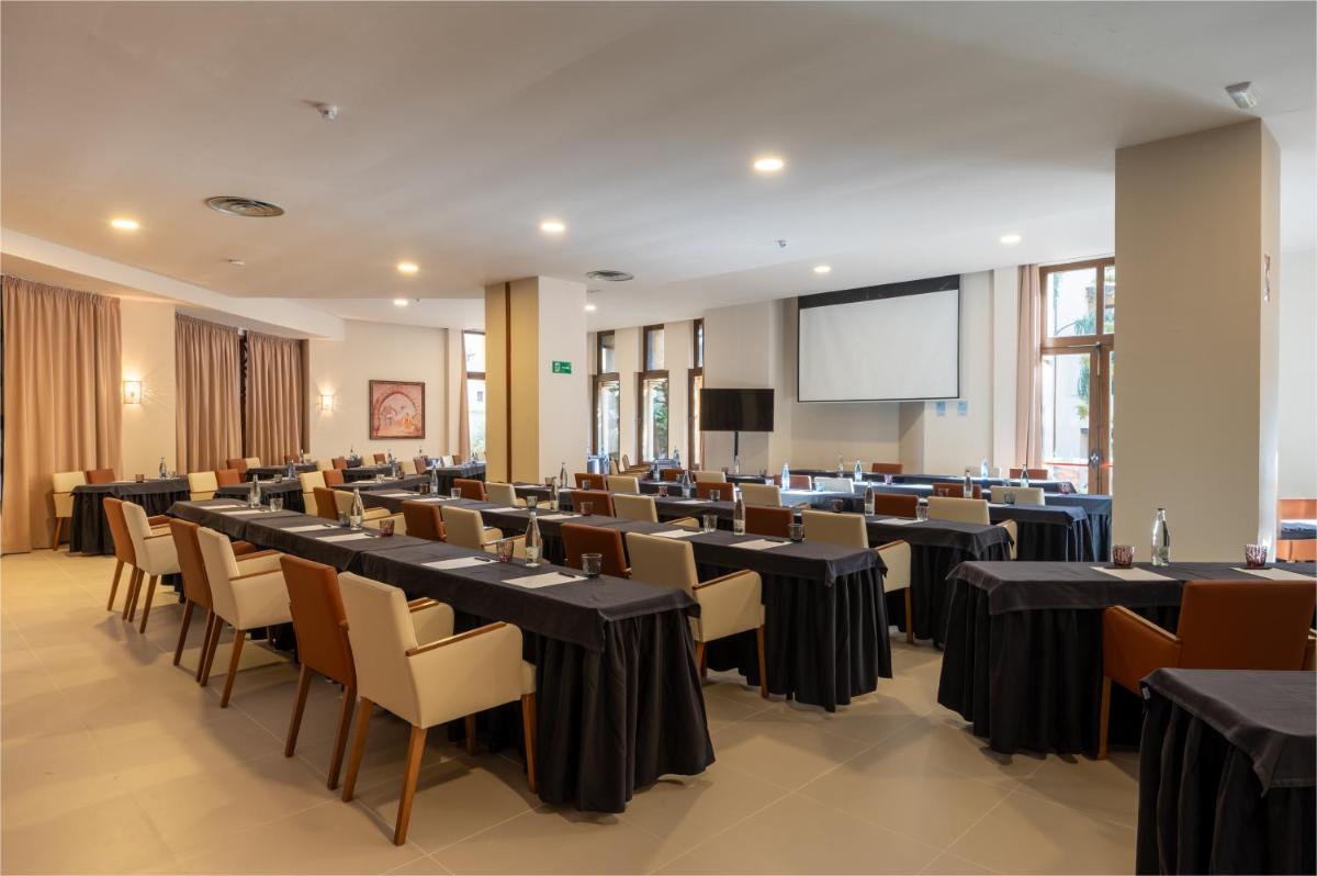 Una sala de conferencias con mesas, sillas y una pantalla. en Vila Gale Isla Canela, en Isla Canela 54 fotos más