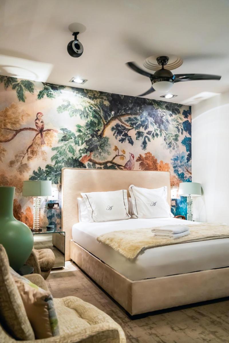 Un dormitorio con una cama grande con una pared floral. en Abalú Design Boutique Hotel Gran Via, en Madrid