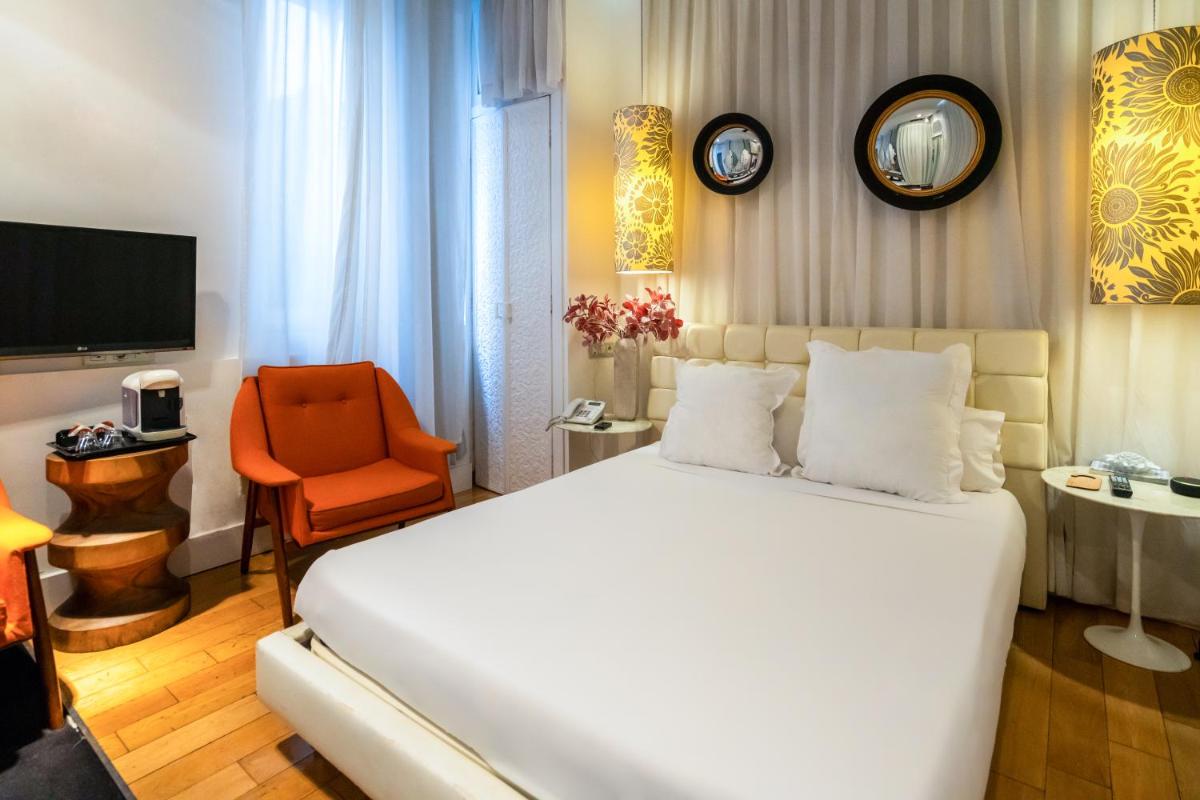 Un dormitorio con una gran cama blanca y una silla. en Abalú Design Boutique Hotel Gran Via, en Madrid