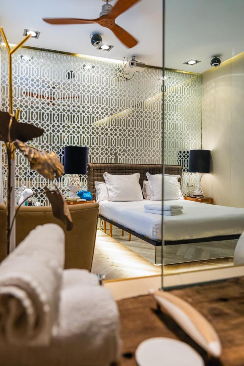 Un dormitorio con una cama y una pared de cristal. en Abalú Design Boutique Hotel Gran Via, en Madrid