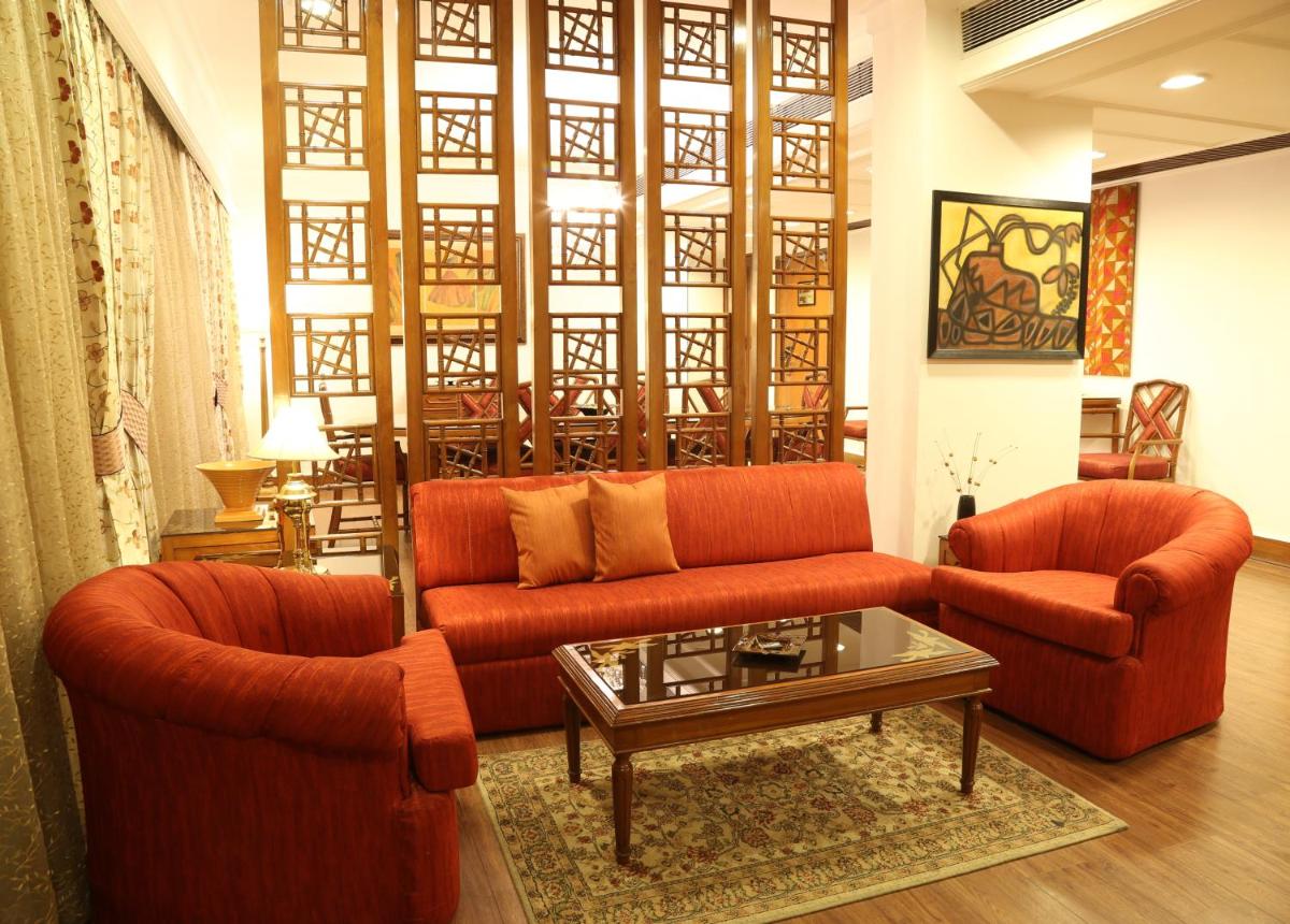 a living room with two orange couches and a coffee table at The Ashok, New Delhi in New Delhi a living room with two orange couches and a coffee table at The Ashok, New Delhi in New Delhi