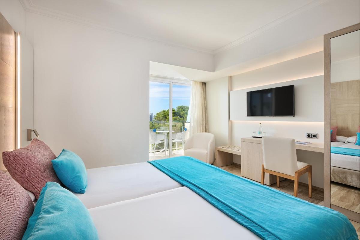 Una habitación de hotel con una cama grande y un escritorio. en Grupotel Orient, en Playa de Palma