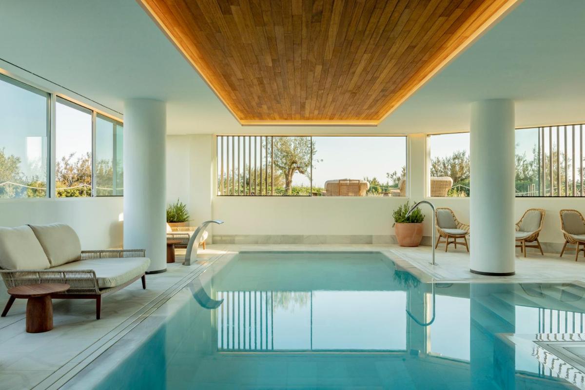 una piscina cubierta con mesa, sillas y ventanas en Villa Le Blanc, a Gran Meliá Hotel - The Leading Hotels of The World, en Santo Tomás