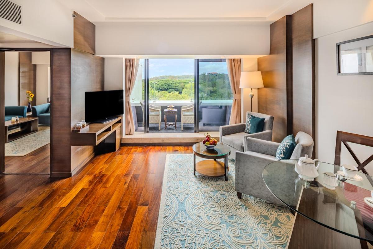 a living room with a couch and a television at Vivanta Goa, Panaji in Panaji a living room with a couch and a television at Vivanta Goa, Panaji in Panaji