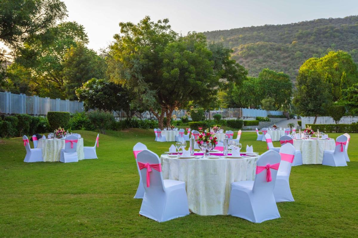 a group of tables with pink and white chairs at DoubleTree By Hilton Jaipur Amer in Jaipur