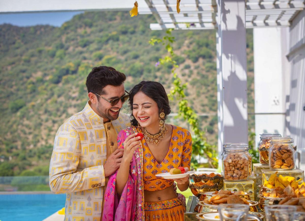 a man and woman standing in front of a table with food at DoubleTree By Hilton Jaipur Amer in Jaipur