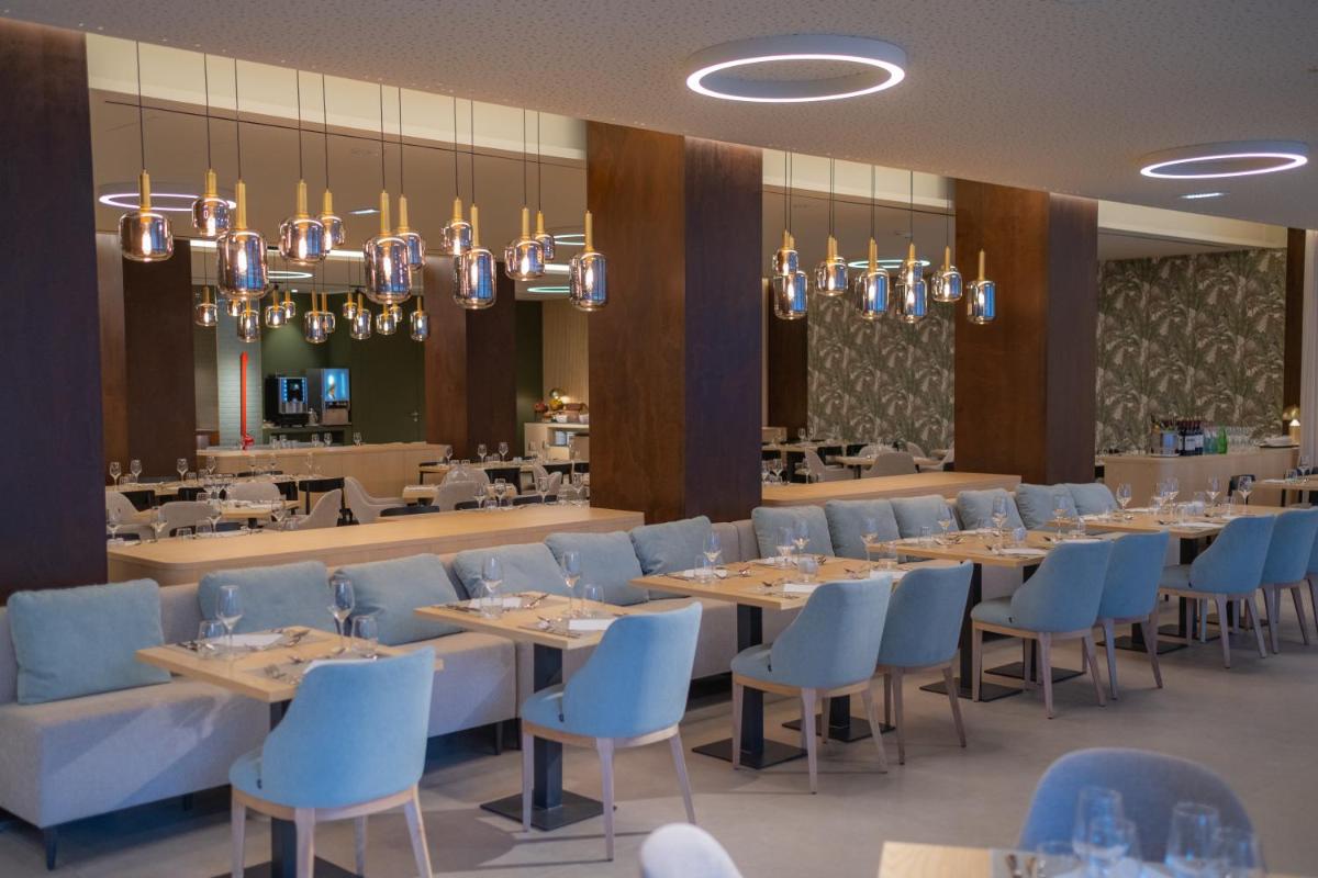uma sala de jantar com mesas e cadeiras azuis em Vila Baleira Porto Santo em Porto Santo