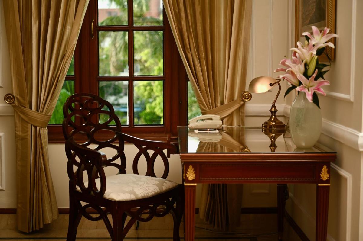 a desk with a phone and a chair next to a window at The Imperial, New Delhi in New Delhi a desk with a phone and a chair next to a window at The Imperial, New Delhi in New Delhi