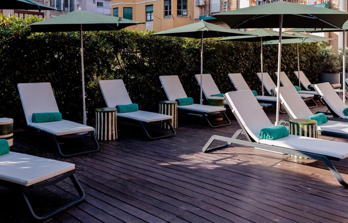 un montón de tumbonas y sombrillas en una terraza en Acevi Villarroel, en Barcelona