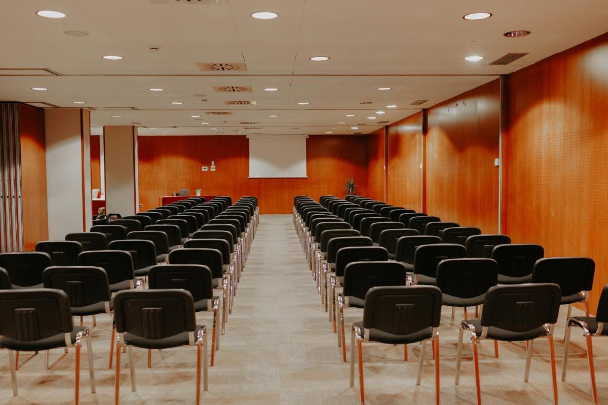 una sala con filas de sillas y un podio en Acevi Villarroel, en Barcelona