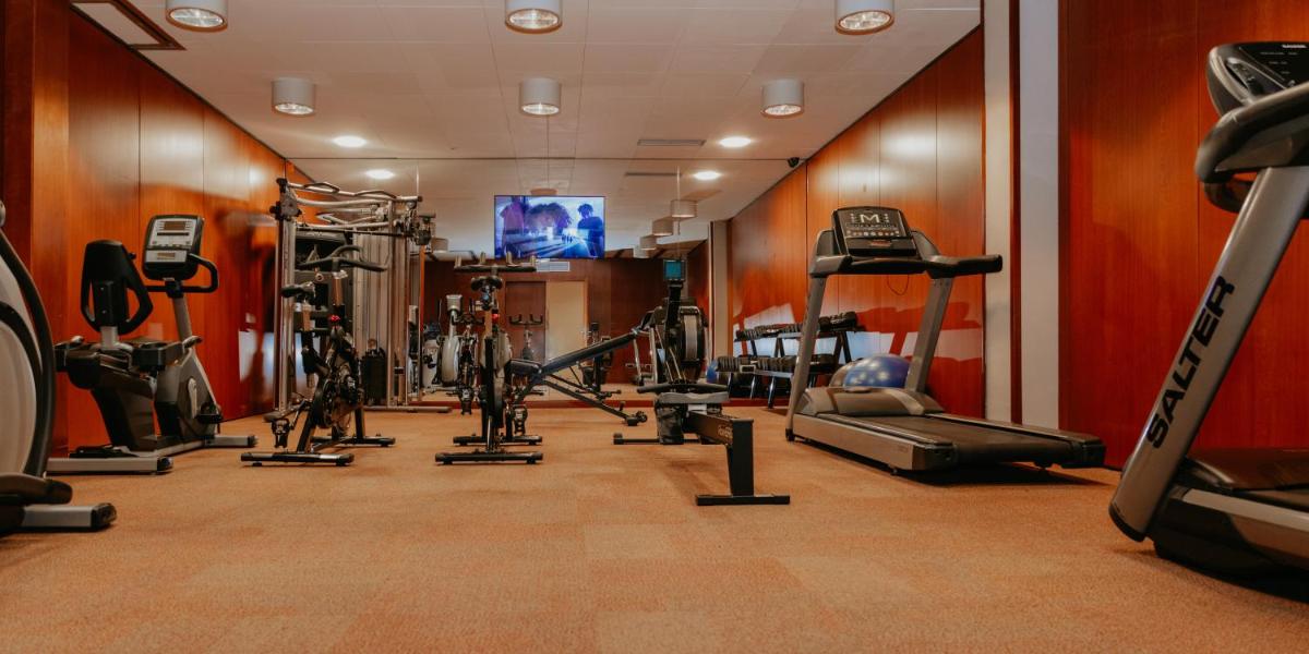 un gimnasio con varias máquinas de correr y TV de pantalla plana en Acevi Villarroel, en Barcelona