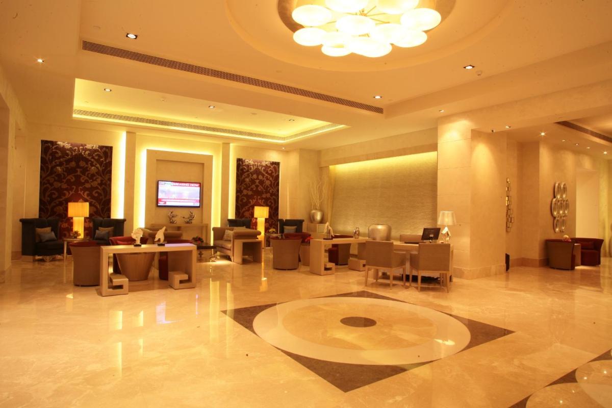 a lobby of a hotel with tables and chairs at Radisson Hyderabad Hitec City in Hyderabad
