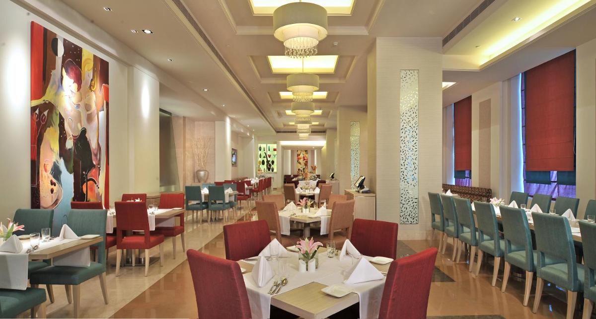 a dining room with tables and chairs in a restaurant at Radisson Hyderabad Hitec City in Hyderabad