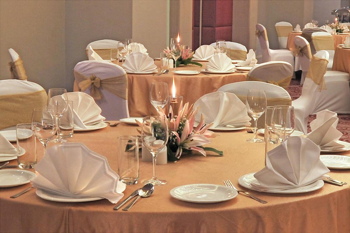 a set of tables with white plates and napkins at Radisson Hyderabad Hitec City in Hyderabad