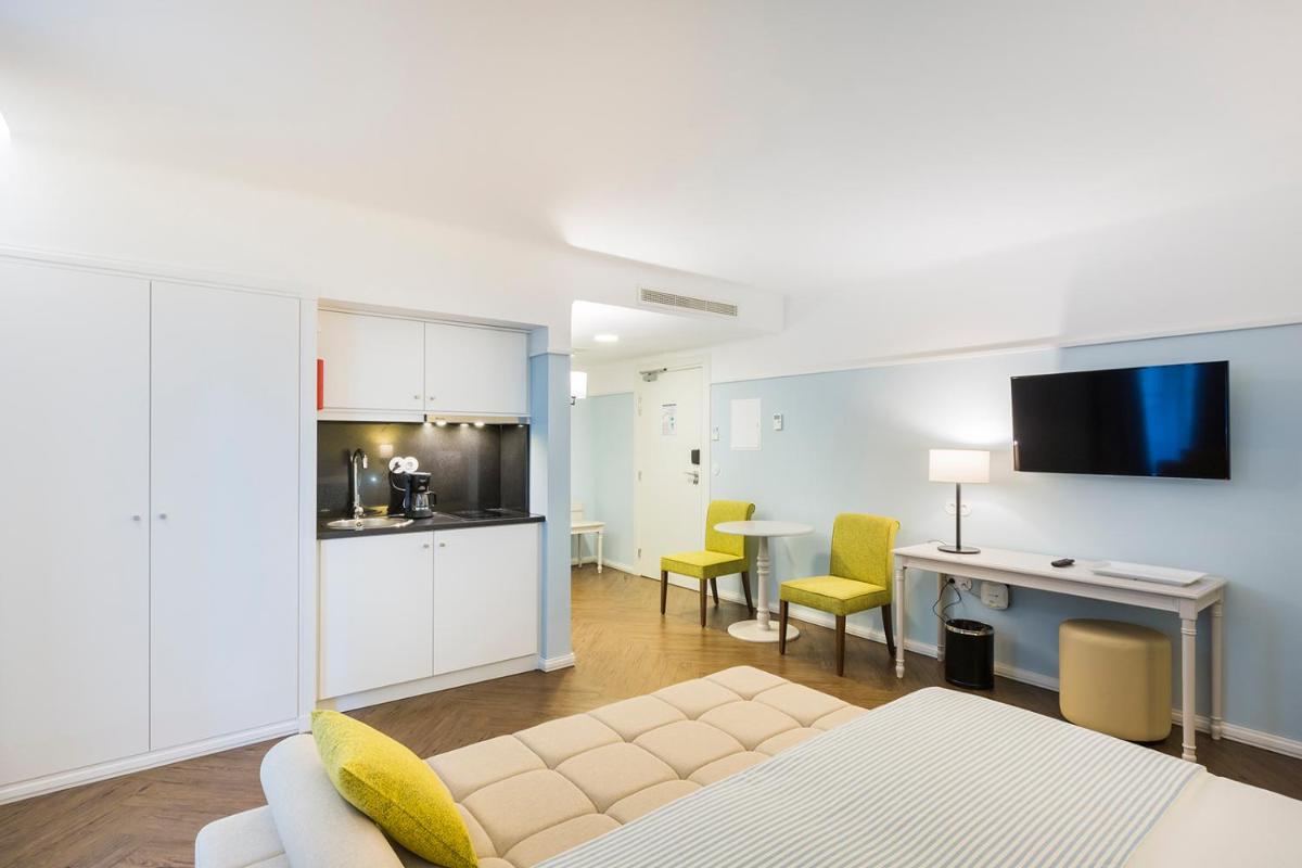 uma sala de estar com um sofá e uma cozinha em Castanheiro Boutique Hotel no Funchal