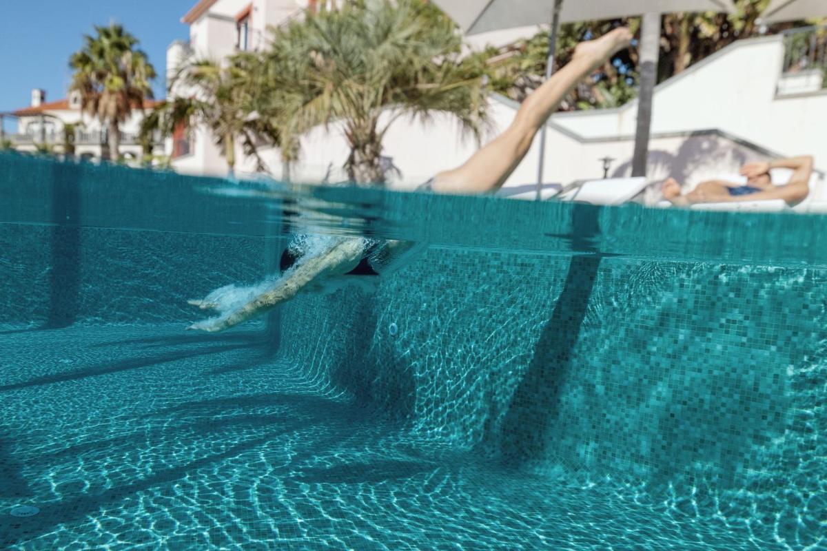 uma pessoa está nadando em uma piscina em Dreams Madeira Resort Spa & Marina no Caniçal