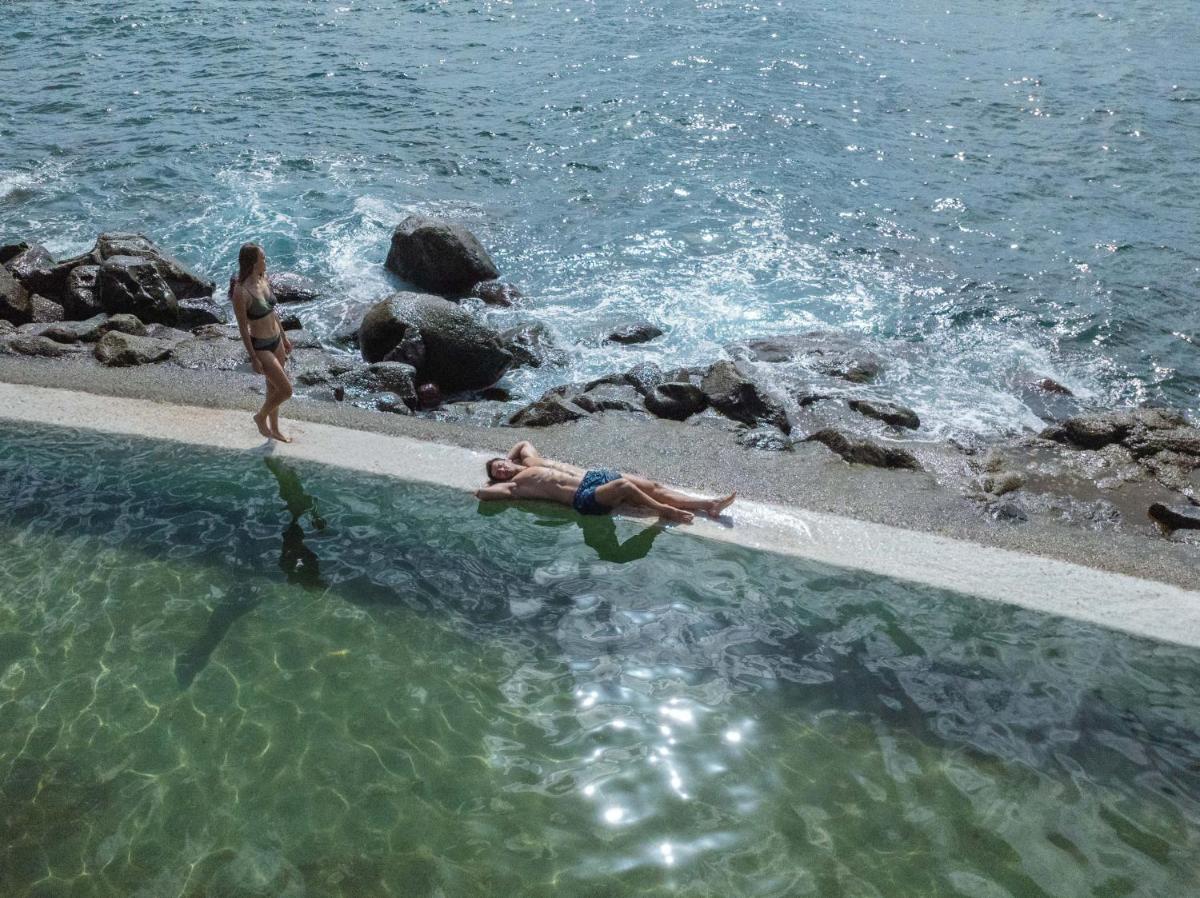 uma mulher e um homem nadando na água em Dreams Madeira Resort Spa & Marina no Caniçal uma mulher e um homem nadando na água em Dreams Madeira Resort Spa & Marina no Caniçal