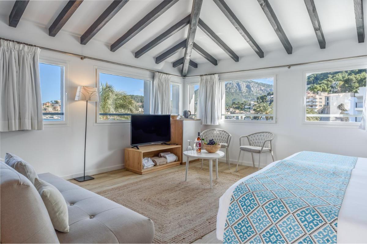 1 dormitorio con 1 cama y TV y algunas ventanas en Hotel Marina, en Puerto de Sóller
