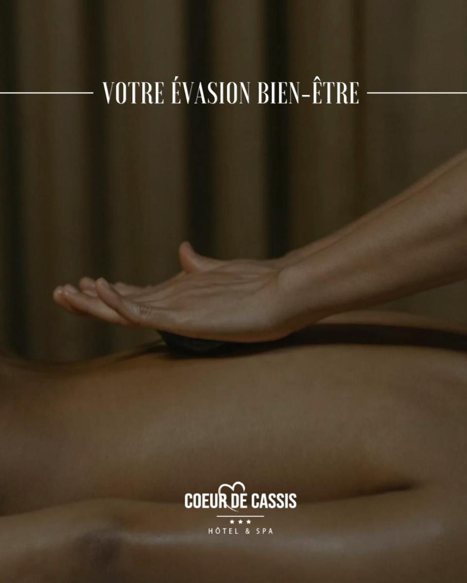 une femme est assise sur un lit avec sa main dans l'établissement Best Western Hotel & SPA Coeur De Cassis, à Cassis