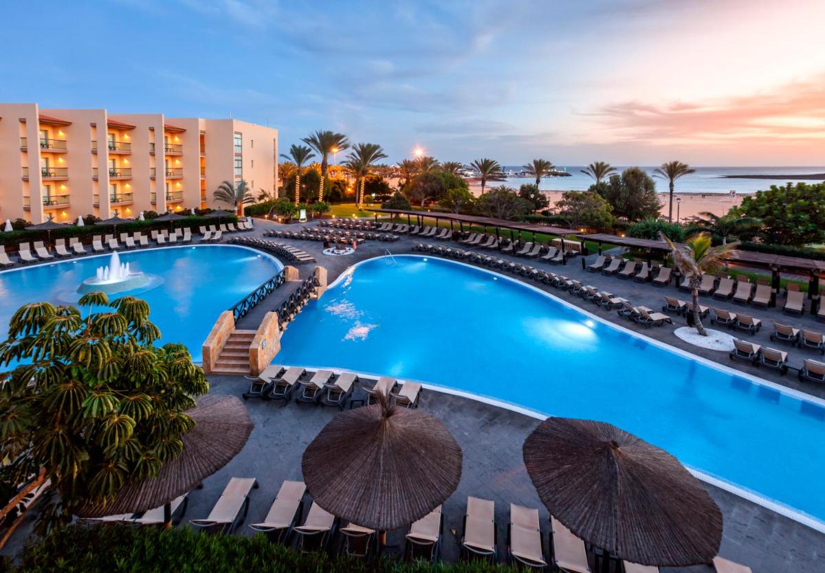 Una vista aérea de una piscina con sillas y sombrillas. en Barceló Fuerteventura Mar, en Caleta de Fuste