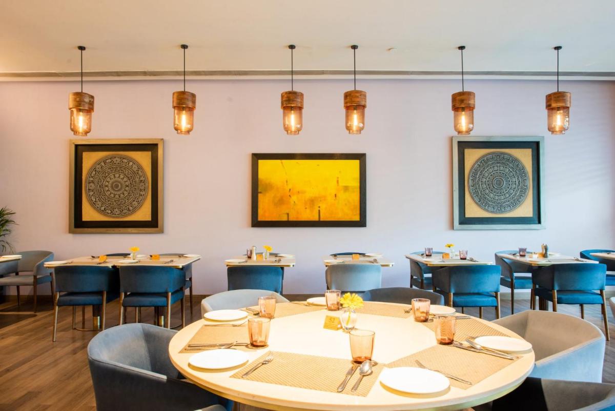 a dining room with tables and chairs and lights at Crowne Plaza Today Gurugram by IHG in Gurgaon