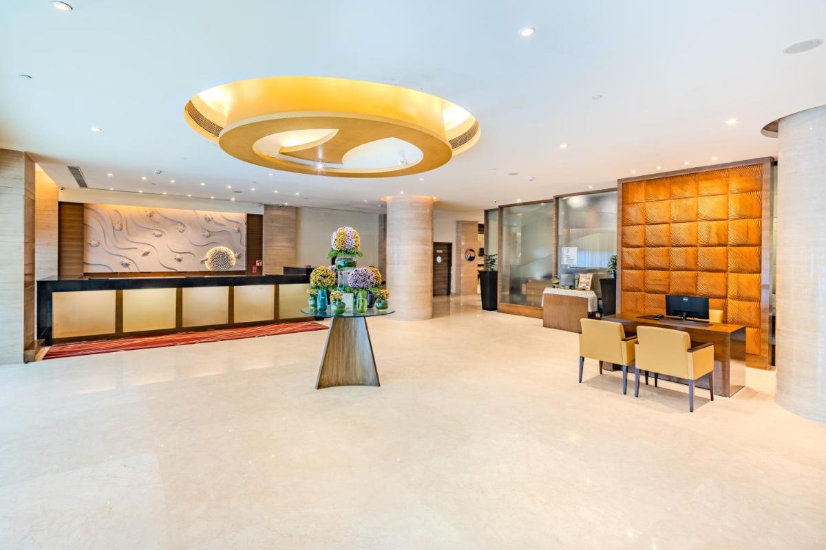 a lobby of a hotel with a table and flowers at Vivanta Goa, Panaji in Panaji +85 photos a lobby of a hotel with a table and flowers at Vivanta Goa, Panaji in Panaji +85 photos